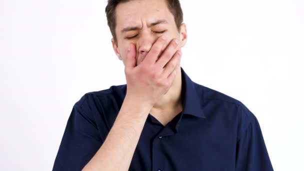 Close up young man yawning isolated on white background — Stock Video