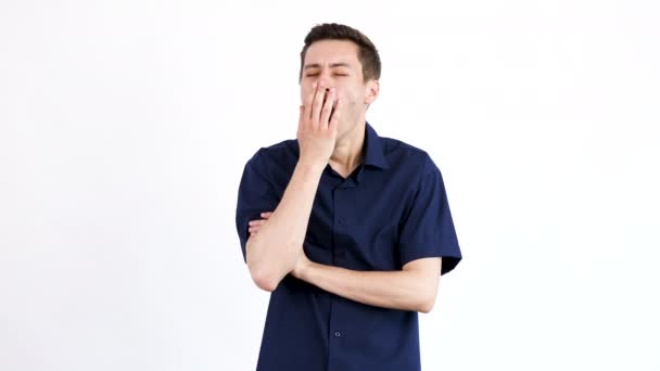 Молодой человек зевает на белом фоне изолирован — стоковое видео