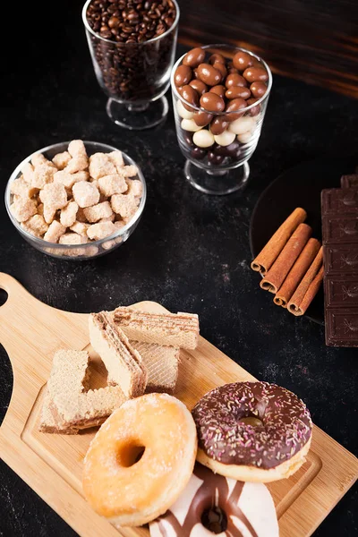 Donuts, cacahuetes en chocolate y granos de café —  Fotos de Stock