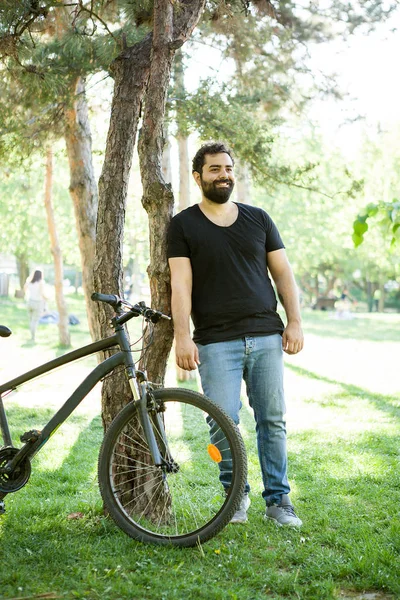 Homem Barbudo Sorridente Apoiado Uma Árvore Parque Lado Sua Bicicleta — Fotografia de Stock