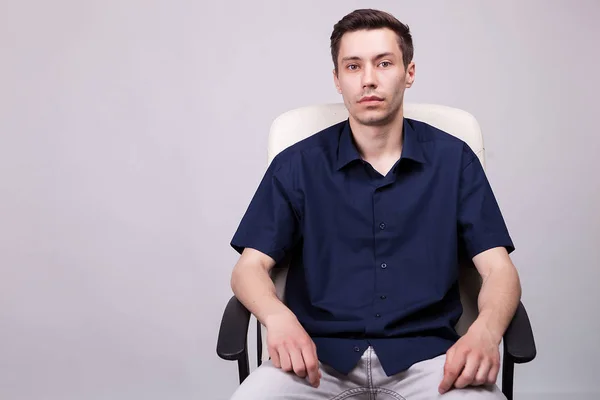 Retrato de un joven hombre de negocios con camisa casual sentado en una silla — Foto de Stock