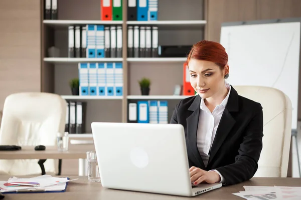 Businesswoman in formal suit working at a laptop — Stock Photo, Image