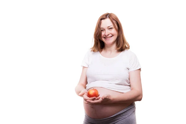 Glücklich schwangere Frau hält einen roten Apfel in den Händen — Stockfoto