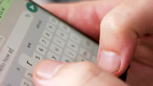 Cerrar las manos del hombre escribiendo un texto en la pantalla del teléfono inteligente — Vídeos de Stock