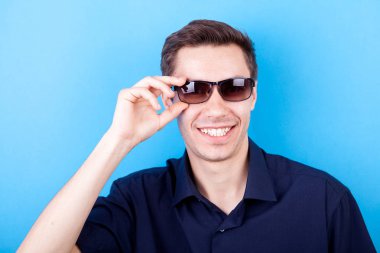 Güneş gözlüğü takıyor rahat tişörtlü serin adam