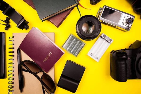 Flatlay sarı zemin üzerine gezgin blogger kitinin üstten görünüm