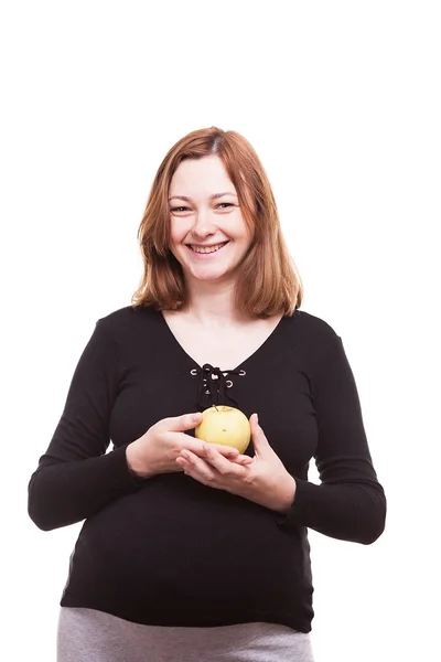 Беременная женщина держит в руках яблоко — стоковое фото