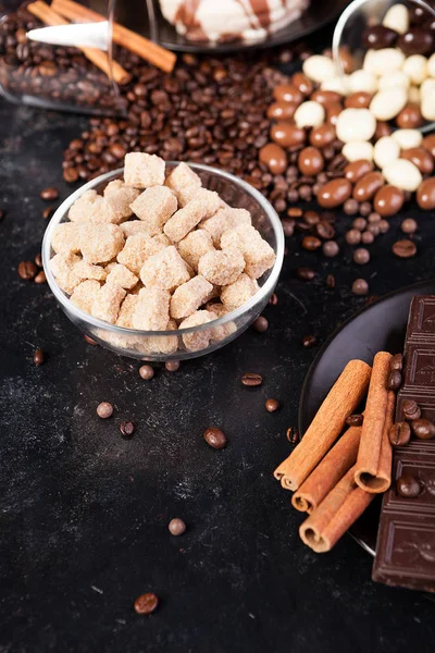 Chocoladetabletten naast kaneel broodjes en andere snoepjes en suikergoed — Stockfoto