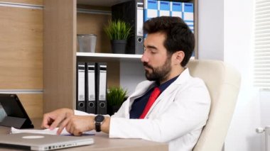 Doktor ofisinde yaptığı Resepsiyon görüşmelerde, sandalye üzerinde oturan