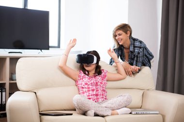 Mutlu çocuk annesi onun yanında ise bir sanal gerçeklik kulaklık ve o dönemin oyunları Oyunlar giyiyor