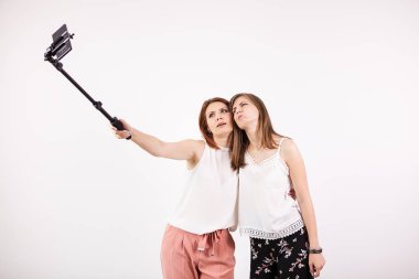 İki güzel genç kadın bir selfie bir selfie sopa ile alarak