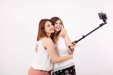 İki güzel genç kadın bir selfie bir selfie sopa ile alarak