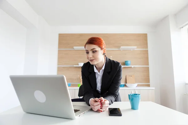 Donna d'affari in abbigliamento formale in cucina con un computer portatile di fronte a lei — Foto Stock