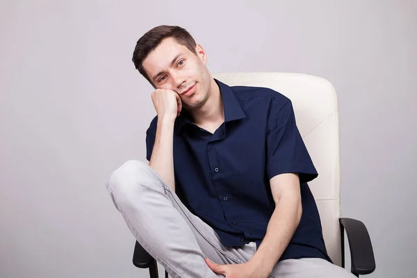 Retrato de un joven hombre de negocios con camisa casual sentado en una silla — Foto de Stock