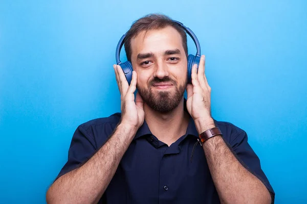 Joven guapo escuchando música a través de auriculares —  Fotos de Stock