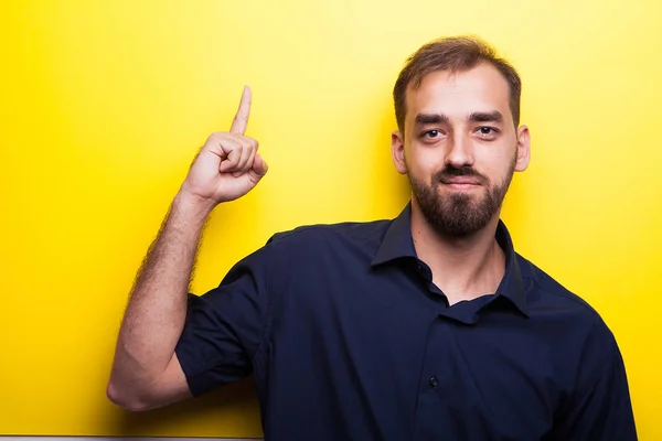 Joven atractivo hombre inteligente mostrando signos de mano apuntando hacia arriba —  Fotos de Stock