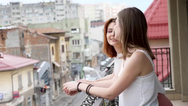 Dvě krásné a mladé ženy mluví a směje se na balkon — Stock video