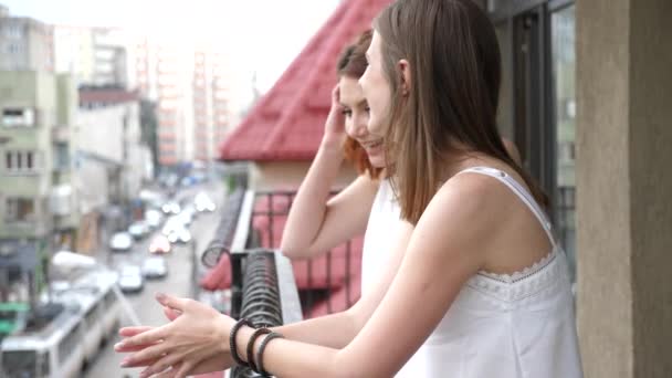 Женщины на балконе смеются и разговаривают — стоковое видео