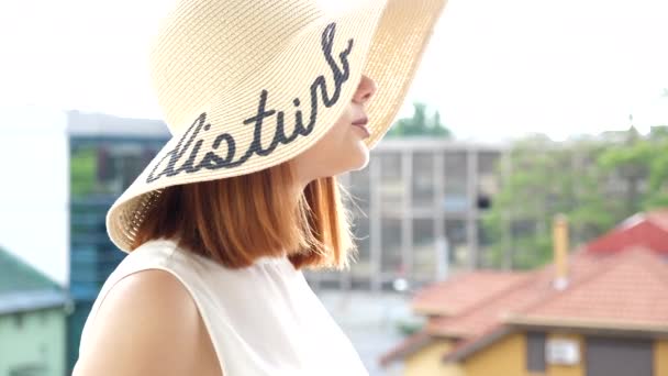 Onthullende shot vrouw in grote zomer hoed op het balkon in gesprek met haar vriend — Stockvideo