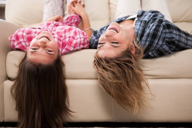 Sevimli kızıyla kanepede kafalarını ile baş aşağı yalan birlikte güzel annem