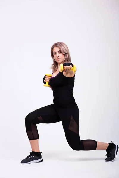 Ajuste mujer en ropa deportiva haciendo ejercicio con dos pequeñas mancuernas —  Fotos de Stock