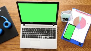 Üstten görünüm dizüstü bir smartphone ile bir tablo üzerinde renk yeşil perde