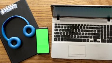 Smartphone ile bir dizüstü bir iş tablo yanında yeşil perde