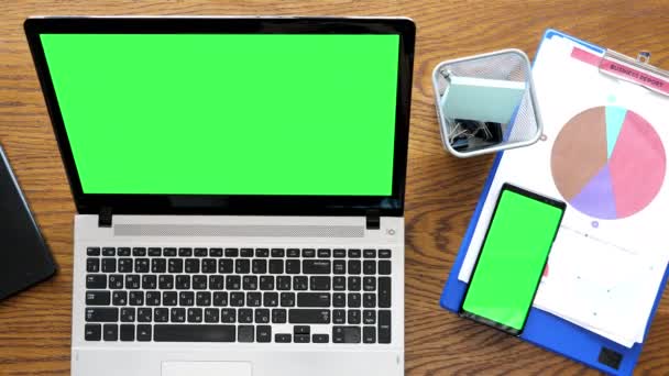Bärbar dator och smartphone med grön skärm på bord — Stockvideo