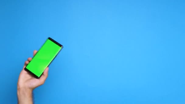 Rising a smartphone with green screen on it — Stock Video