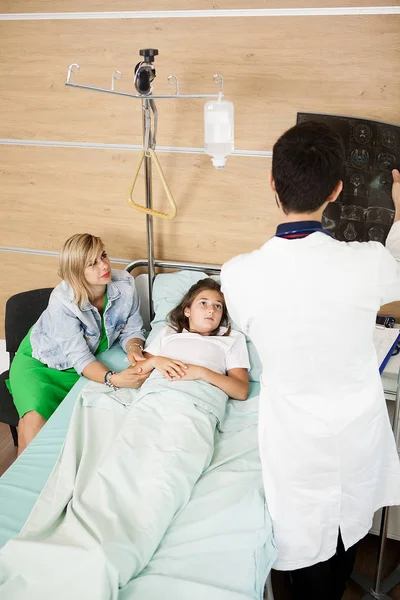 Läkare läsa xray resultaten till hennes patient — Stockfoto