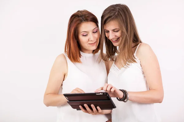 Porträt zweier wunderschöner Frauen mit einem Tablet-PC — Stockfoto