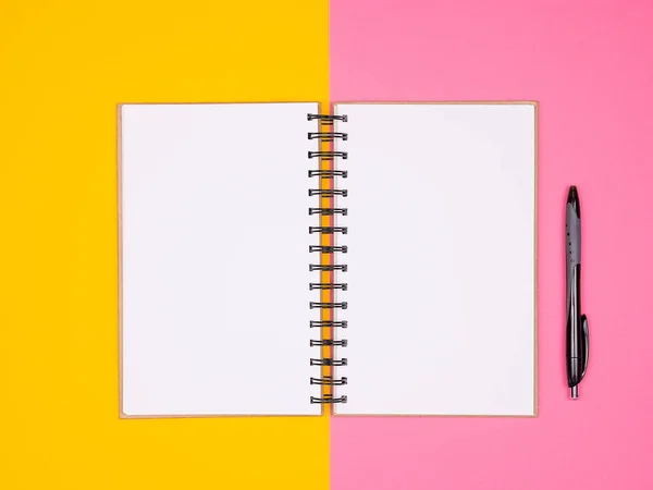 Abra o caderno de papel ao lado de uma caneta em dois fundos coloridos — Fotografia de Stock