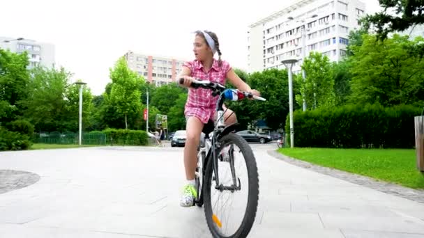 Low angle pretty teenage girl rides a bicycle — Stock Video