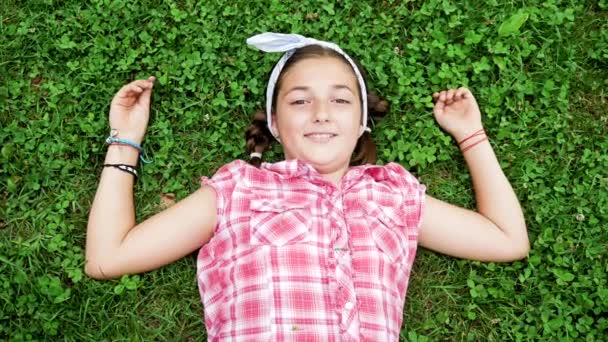 Vue du dessus jolie jeune fille couchée dans le parc sur l'herbe — Video