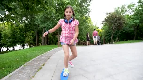 Belle fille dans le parc promenades sur un patin — Video