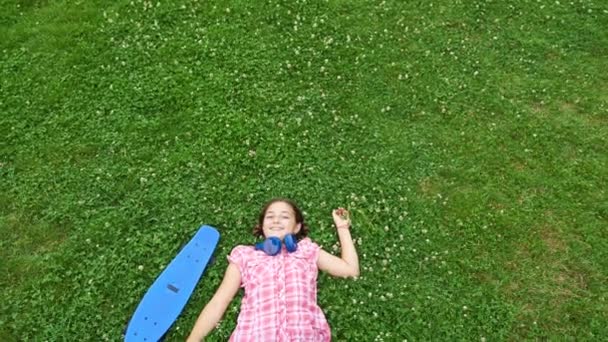 Bovenaanzicht van lachende meisje op het gras — Stockvideo