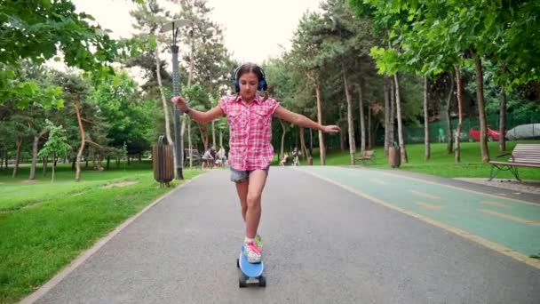 Jovem bonito menina patins no parque — Vídeo de Stock