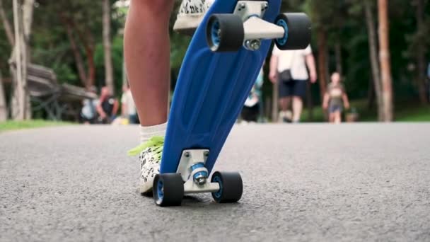 Close up van jong meisje benen krijgen op een blauwe skateboard — Stockvideo