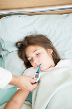 Doktor hastasını vücut sıcaklığı alarak 