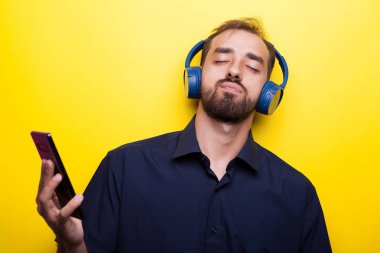 Komik iyi bak genç adam onun smartphone üzerinden müzik keyfi