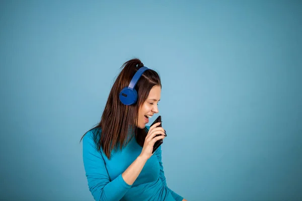 Söt ung kvinna sjunger på sin telefon när man dansar — Stockfoto