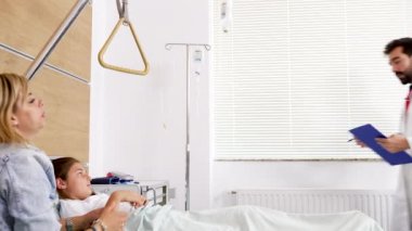 Doktor elinde bir pano ile gelir ve Genç kız hastaya denetler