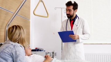 Doktor gülümseyen hasta bir genç kız yapma eller içinde clipboard ile