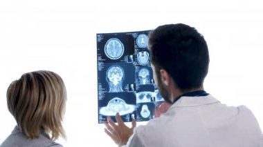 Dcotor bir hastayla büyük beyaz ekran önünde bir MRI tarama denetimi