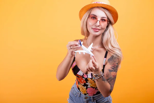 Attraente giovane donna che gioca con aereo giocattolo — Foto Stock