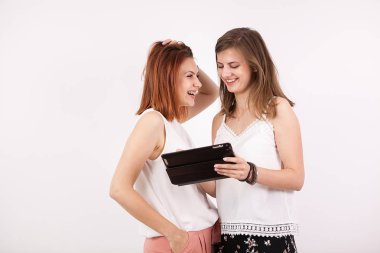 İki kız gülümseyerek ve bir tablet Pc vasıl arıyorum arkadaşlar