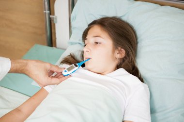 Doktor hastasını vücut sıcaklığı alarak 