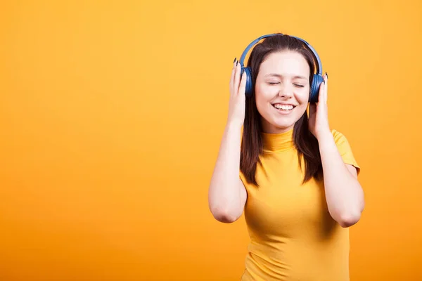 Bonito jovem mulher ouvindo música no estúdio — Fotografia de Stock