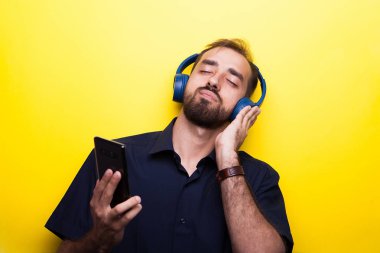 Komik iyi bak genç adam onun smartphone üzerinden müzik keyfi