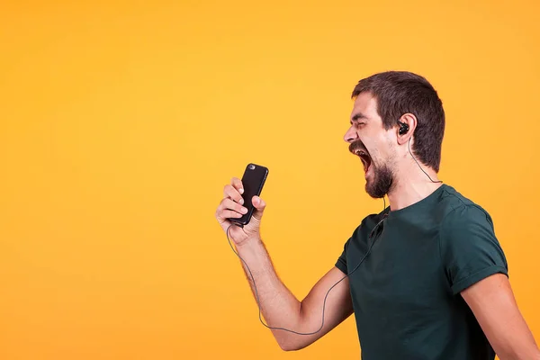 Cool vrolijke jongeman luisteren muziek in zijn hoofdtelefoon — Stockfoto